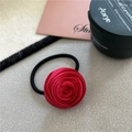 Close-up of a handmade dark red velvet rose hair tie with high-elastic black cord - Red