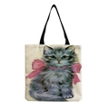 Detail of beige cotton linen tote bag featuring a cute grey cat with a pink bow print - Grey Cat with Bow