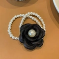 Elegant hair tie featuring a black camellia fabric flower with central pearl detail - Camellia Pearl Style / Black