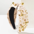 Macro shot of cream knotted headband with golden beads and champagne rhinestones decoration - Beige