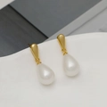Elegant gold drop earrings with teardrop pearls displayed on a white ceramic edge - 18K Gold With 925 Silver Pin