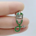 Green enamel stethoscope brooch pin with silver metal base shown in hand for scale - Grass Green with Silver Base