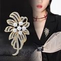 Spilla a fiore dorata elegante con perle e strass su una giacca nera formale - Oro