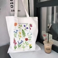 White canvas tote bag with colorful British wild flowers botanical print pattern - British Wild Flowers Guide (STD344-P)