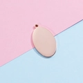 Dettaglio di un ciondolo ovale in acciaio inossidabile oro rosa lucido per gioielli DIY - Oro rosa