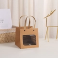 Detail of kraft paper gift bag featuring a square transparent window and paper handles - Open Window Natural 10x10x10cm