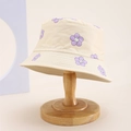 Detail of beige cotton bucket hat with purple floral patterns on a wooden stand - Kids One Size / Beige (Smile Flower Print)