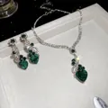 Detalle del conjunto de joyas con corazón verde, collar y pendientes en terciopelo - Conjunto - Verde