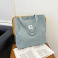 Lichtblauwe corduroy shopper met magneetsluiting en minimalistische patch op leren stoel - Blauw