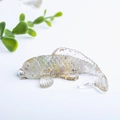 Transparent koi fish resin ornament with purple crystals and gold flakes on white background - Colorful Fluorite