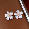 Dettaglio orecchini a fiore con smalto bianco, perline turchesi e cristalli centrali - Orecchini