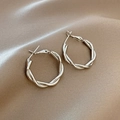 Silver metallic twisted hoop earrings displayed on soft khaki silk fabric background - Silver Metal Twisted Style (E036)