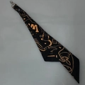 Makrodetail des Baumwoll-Bandanas mit Vintage-Muster und metallischem Drehkarabiner - Schal-Anhänger / Schwarzer Cowboy mit Ring