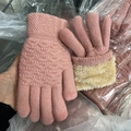 Detail of pink knitted gloves featuring warm beige plush cuffs and wavy woven texture - Peach