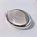 Specchio compatto pieghevole argento con spazzola e incisione su uno sfondo bianco - Spazzola Specchio Pieghevole Ovale in Argento Galvanizzato
