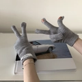 Detalle de guantes de punto grises con aberturas en los dedos y etiquetas blancas de muñeca - Gris