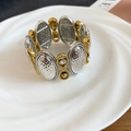 Dettaglio del bracciale elastico bicolore con finitura martellata e zirconi chiari - Stile Simbolo dell'Infinito Martellato Ovale / Oro-Argento
