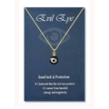 Close-up of a gold-plated evil eye pendant necklace on a blue gift display card - 18K Gold Black Bead (Black Eye)
