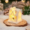 Mini white decorative house with LED lights and snow effect on a rustic wood slice - Snow House C
