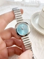 Detail of silver women's watch with light blue dial held against a white tea cup - Silver Band Blue Dial