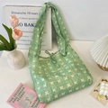Detail of light green floral tote bag featuring a knotted shoulder strap and bow ribbon - Green Lotus Ribbon Style