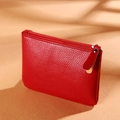 Red lychee pattern PU leather coin purse with zipper closure on warm background - Red
