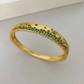 Macro shot of gold bracelet featuring intricate pavé-set green cubic zirconia stones - Gold Green Zirconia