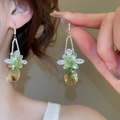Detailed close-up of tassel earrings with clear and green crystals in golden finish - Gold Green