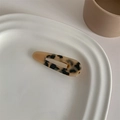 Close-up of a tortoiseshell acetate hair clip with cream color block on a ceramic plate - Light Leopard Water Drop