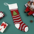 Knitted Christmas stocking with green tree pattern and white cuff on dark green background - Christmas Tree