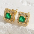 Macro shot of vintage gold stud earrings with square green zircon and diamond halo - Green