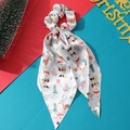 Detailed view of white Christmas fabric scrunchie with ribbons and Santa Claus patterns - White