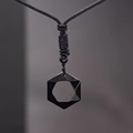 Nahaufnahme eines polierten schwarzen Obsidian-Anhängers an einer gewebten Kordelkette - Hexagramm mit schwarzem Seil