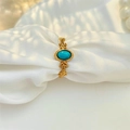 Detail of vintage gold ring with oval turquoise stone on white silk background - Adjustable Open / Gold - Synthetic Turquoise