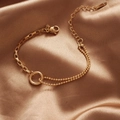 Asymmetrical gold titanium steel bracelet featuring a circle link and adjustable chain - Gold
