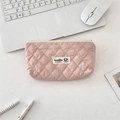Pink quilted rhombic makeup bag shown on a desk with a laptop and stationery - Nude Pink
