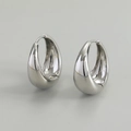 Macro detail of high-polished S925 sterling silver teardrop earrings with hallmark - White Gold