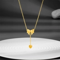 Elegant gold bow necklace with heart pendant on a white ceramic tray for women - Gold
