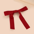 Detailopname van de donkerrode strik haarclip met een elegante satijnen stoftextuur - Rood