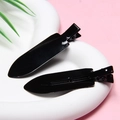 Detail view of two glossy black metal alligator hair clips on a pink background - Black - Glossy without Letters