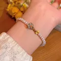 Pulsera de perlas vintage con dije de pétalo gris y moneda de oro en la muñeca - S786 Blanco-Verde - Pulsera de Perlas de Flores