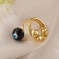 Dettaglio macro di anello malocchio placcato oro con perla su seta beige - Aperto Regolabile / Occhio del diavolo nero