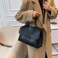 Fashionable black crocodile pattern tote bag with flap design shown in an indoor setting - Black