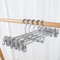 Space-saving grey plastic pants hangers with adjustable non-slip clips on a wooden rail - Non-slip Pant Clip-Grey