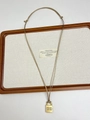Macro detail of golden padlock pendant on a cord chain over a wooden tray - Gold Lock