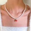 Dettaglio della collana di perle con ciliegie sul collo della modella, stile vellutato - Collana con Pendente Ciliegia Rossa Perla Oro (12028)