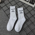 White crew socks with black Perfection Is Boring slogan and ribbed cuffs in street style - Perfection Is Boring