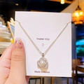 Variante de collier argenté avec pendentif perle et zircons sur une carte de présentation - Perle de Camélia Argentée
