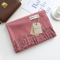 Pink cashmere-feel winter scarf with tassels folded next to a brown bag and magazine - Dust Rose / 200cm