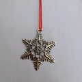 Polished silver metal snowflake Christmas ornament with red string for festive hanging decor - Snowflake
